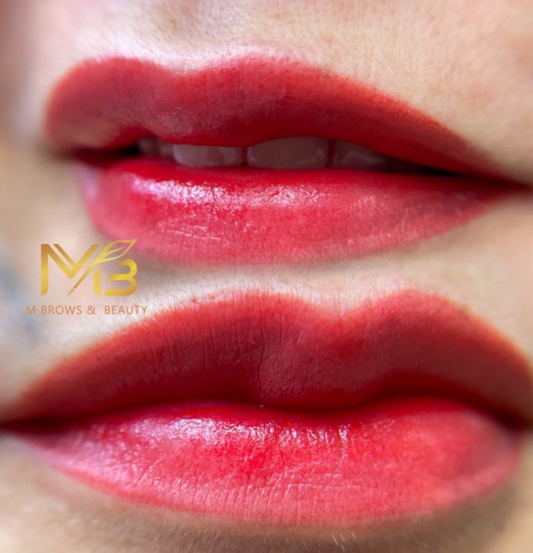 M Brows and Beauty Close-up of a person's lips with bright red lip tint and a soft gradient effect. The skin appears smooth, and the logo "M Brows & Beauty" is visible on the left side of the image.